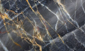 Primo piano di una lastra di marmo scuro con venature dorate e bianche